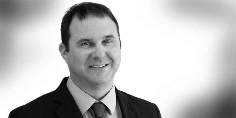 Headshot of attorney Justin Swaim, black and white