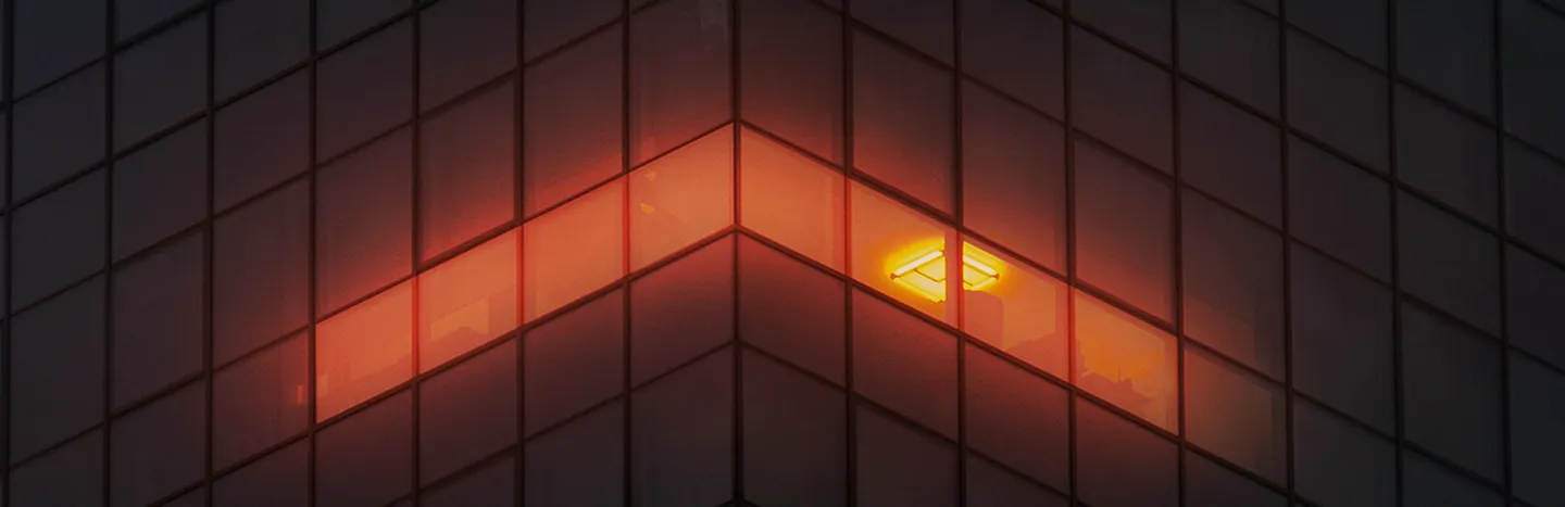 Dark office building with single orange light on